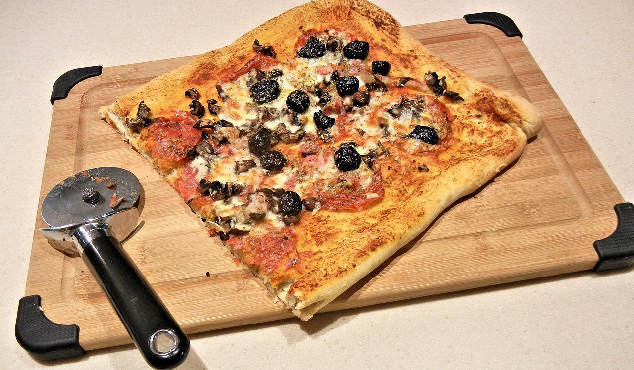 Immagine di una pizza fatta in casa con impasto dorato e ingredienti freschi, pronta per essere servita.