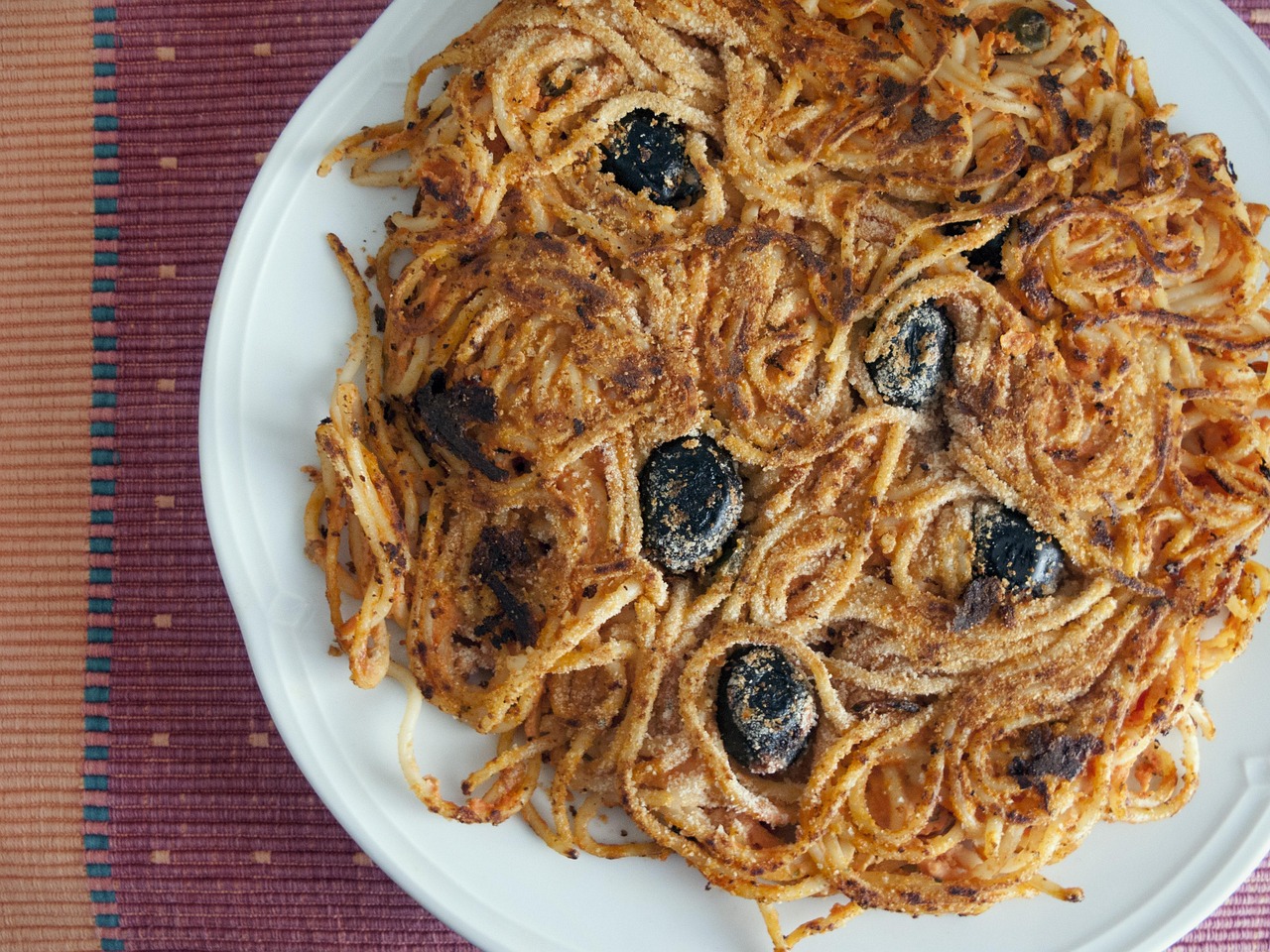 Frittata di pasta napoletana dorata e gustosa, servita su un piatto decorato.