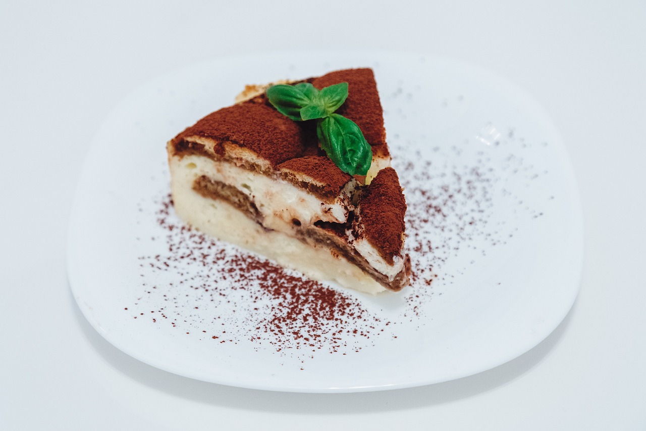 Tiramisù senza uova decorato, con crema soffice e caffè, su fondo neutro.
