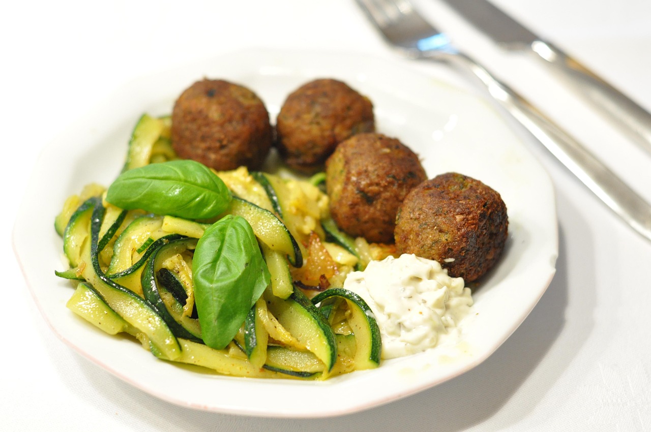 Polpette di melanzane dorate servite su un piatto bianco, guarnite con prezzemolo fresco.