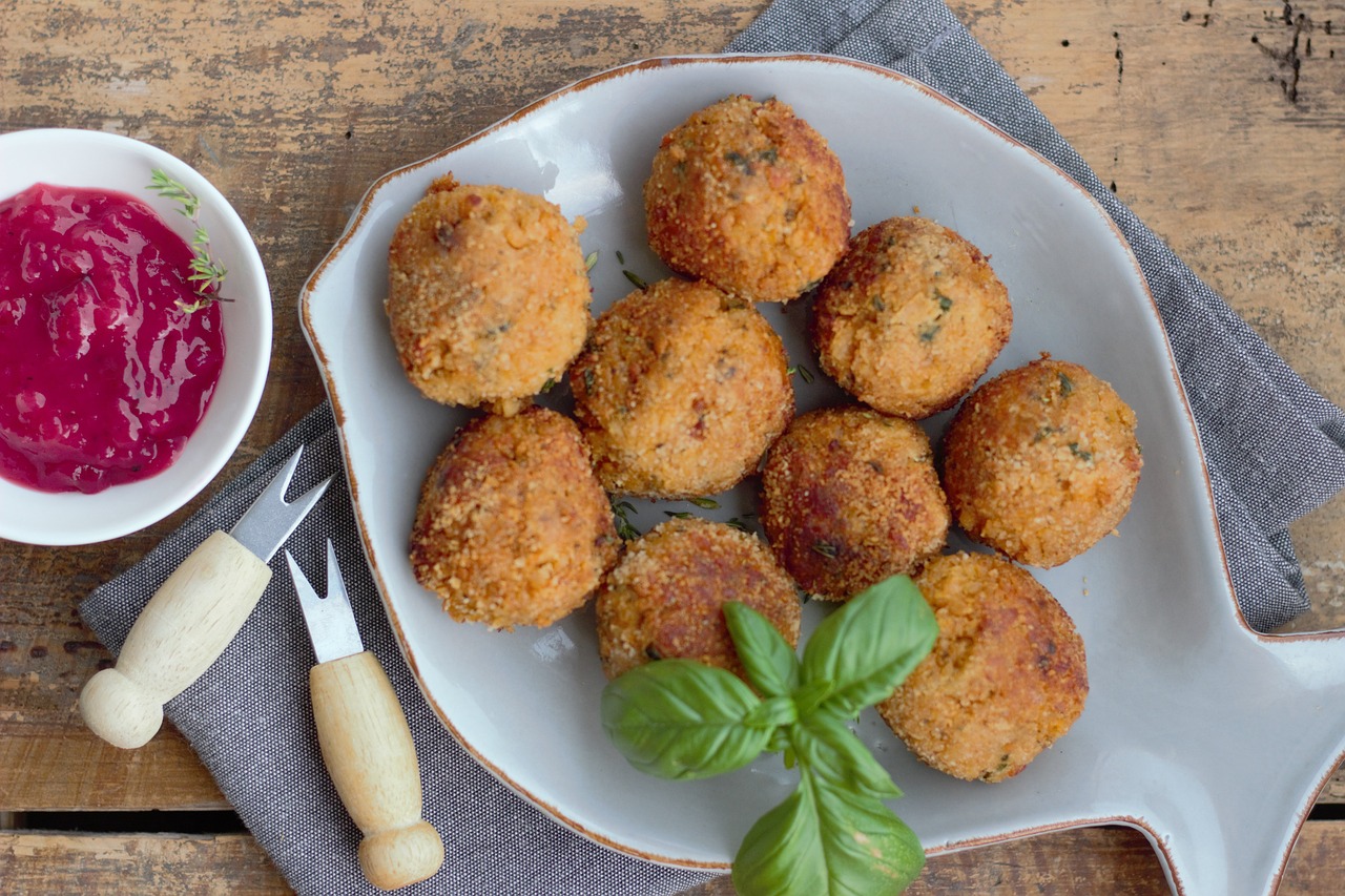 Polpette di tonno dorate servite su un piatto con contorno di insalata fresca.